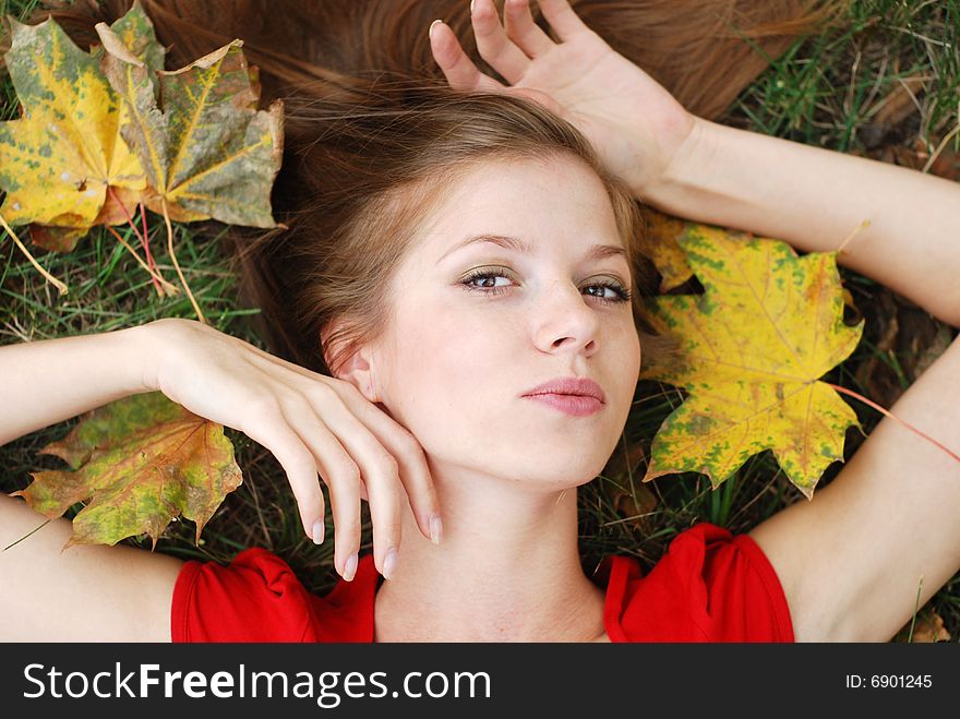 Young beautiful woman with maple leaf around her face