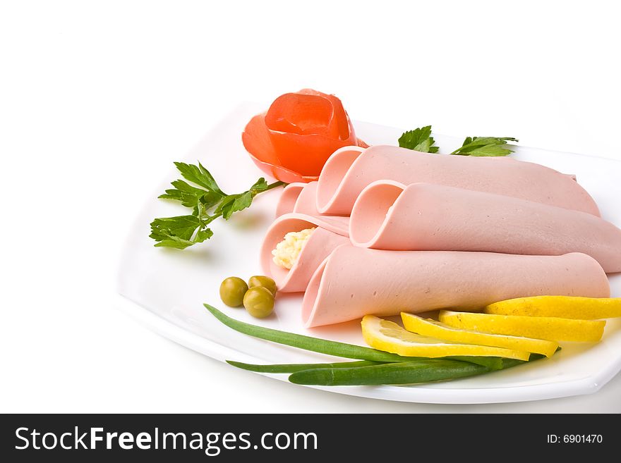 Rolls from sausage and cheese with vegetables on a white background