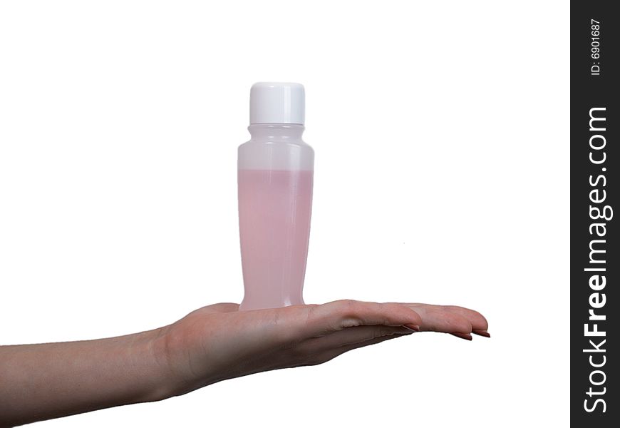 The female hand holds on an open palm a small bottle with perfumery on a white background. The female hand holds on an open palm a small bottle with perfumery on a white background