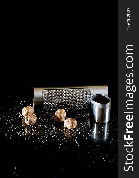 Nutmeg and silver grater on black background