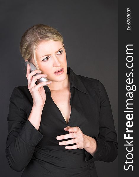 Worried looking blond businesswoman in conversation on the phone. Worried looking blond businesswoman in conversation on the phone