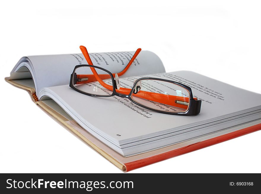 Orange and black spectacles on an open book. Orange and black spectacles on an open book.