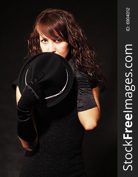 The girl in black clothes on a white background with a hat hat