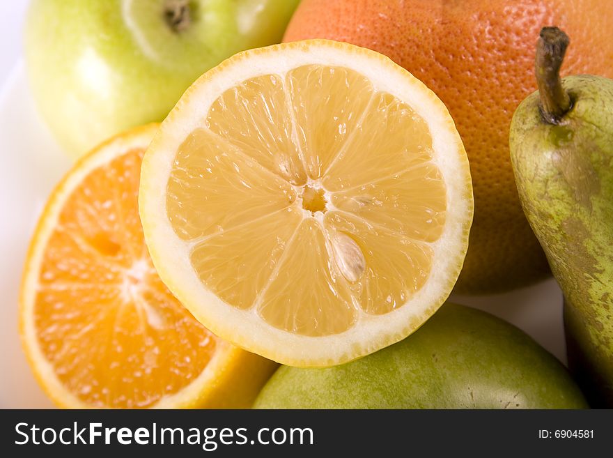 Fruit salad with lemon on the top. Contains many different citrus fruits
