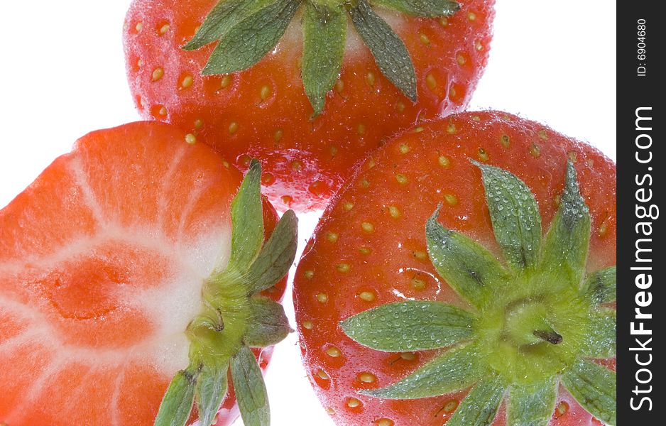 Three strawberries (one cut) on the white background