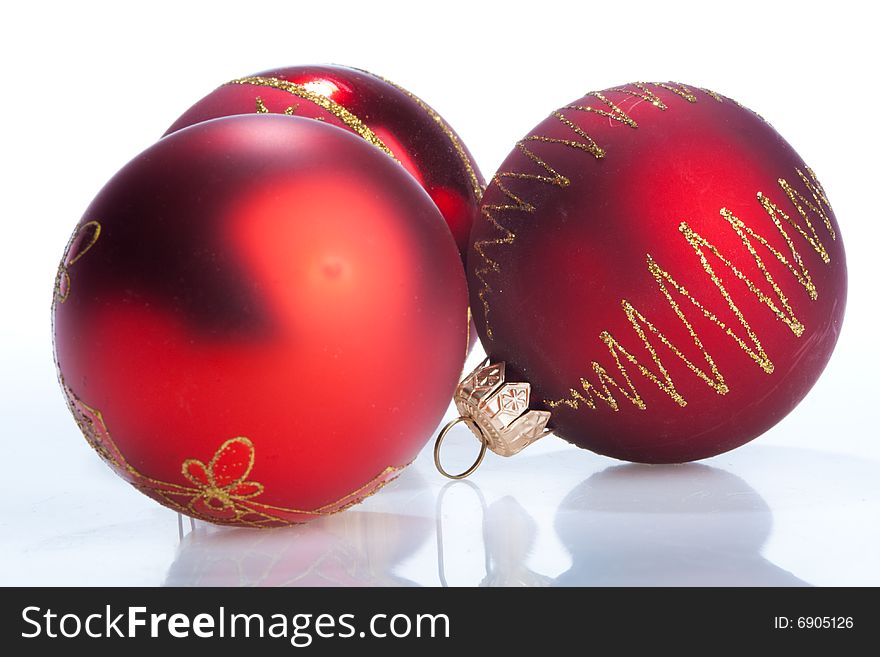 Three red New Year balls, isolated over white with reflection