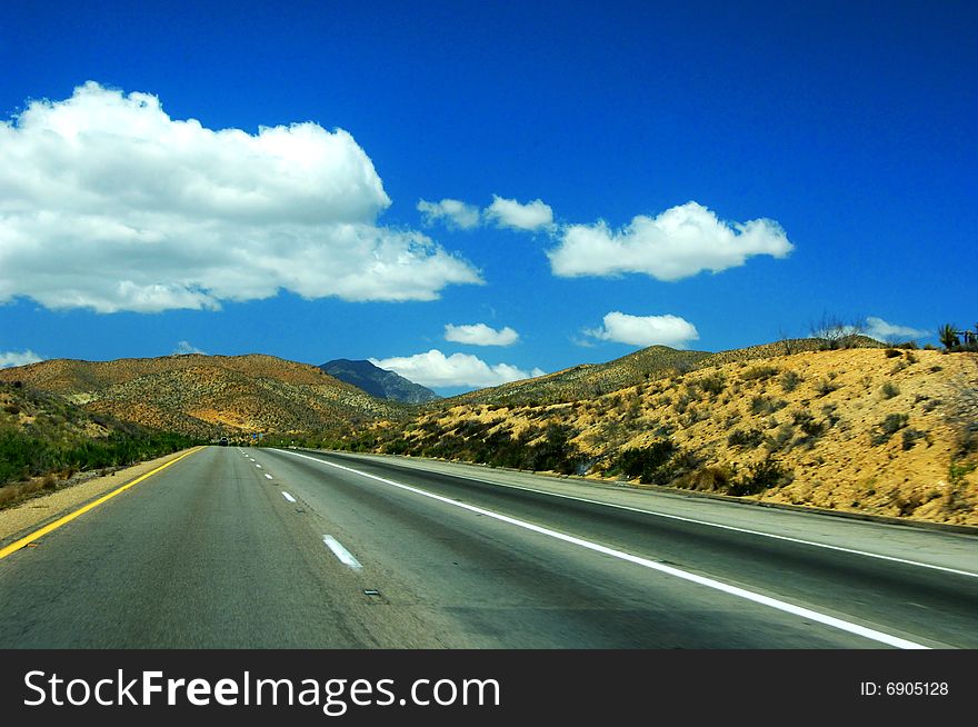 Empty highway, clouds and the blue sky