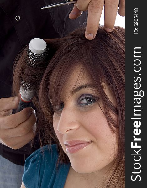 Female taking haircut against white background