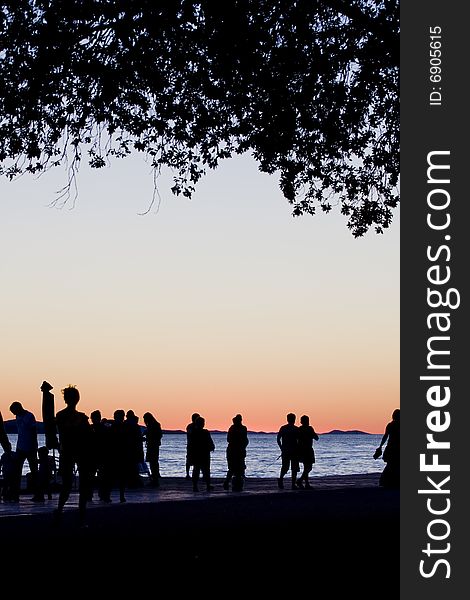 People by the sea at sunset in Zadar, croatia