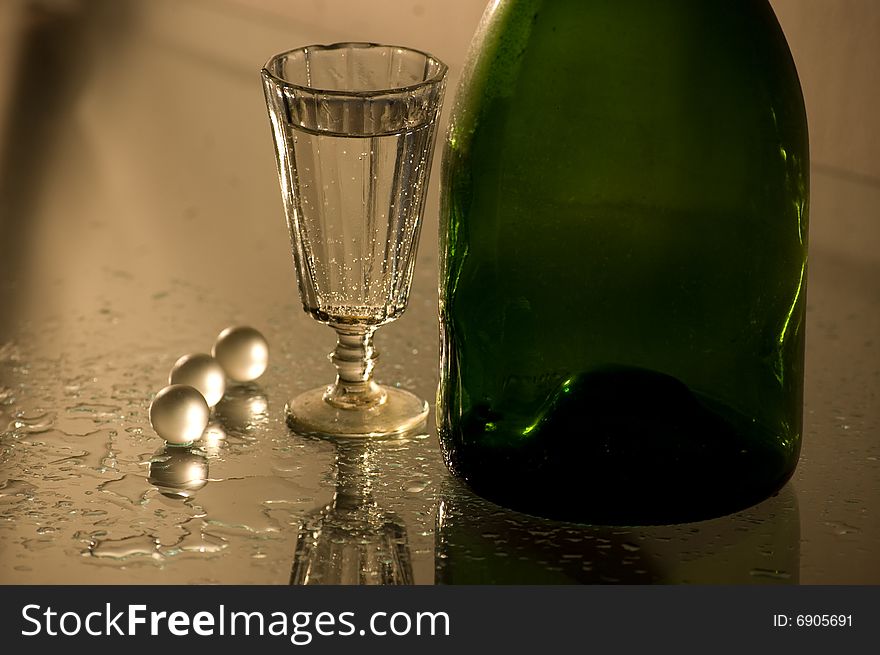 Glass with champagne and green bottle. Glass with champagne and green bottle