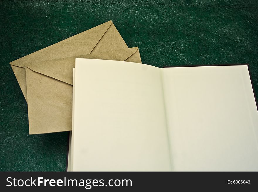Open book and envelopes on a green background