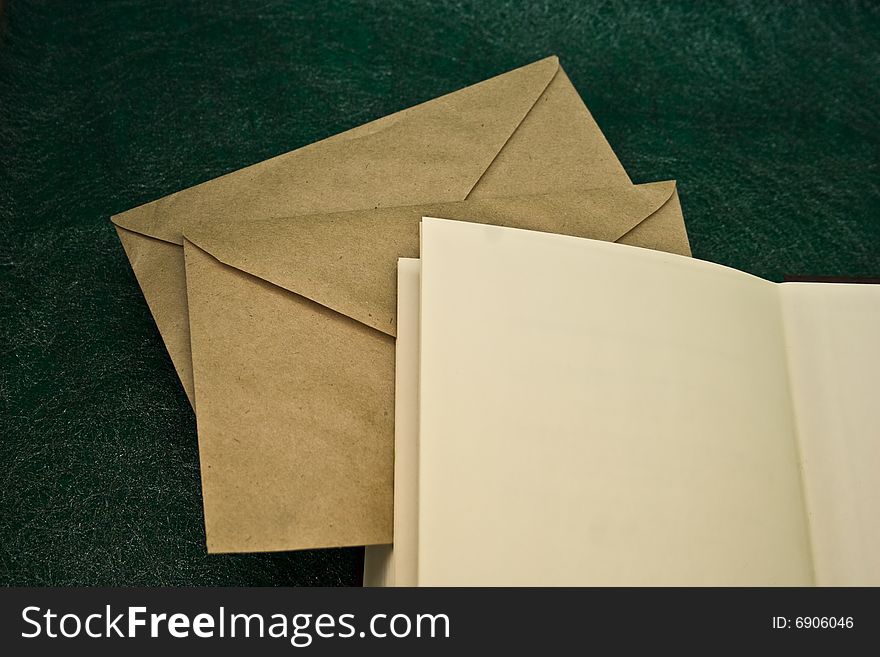 Open book and envelopes on a green background