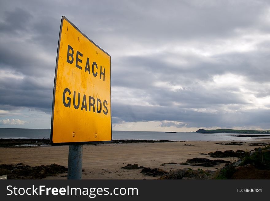 A deserted beach showing a Beach Guard Sign. A deserted beach showing a Beach Guard Sign
