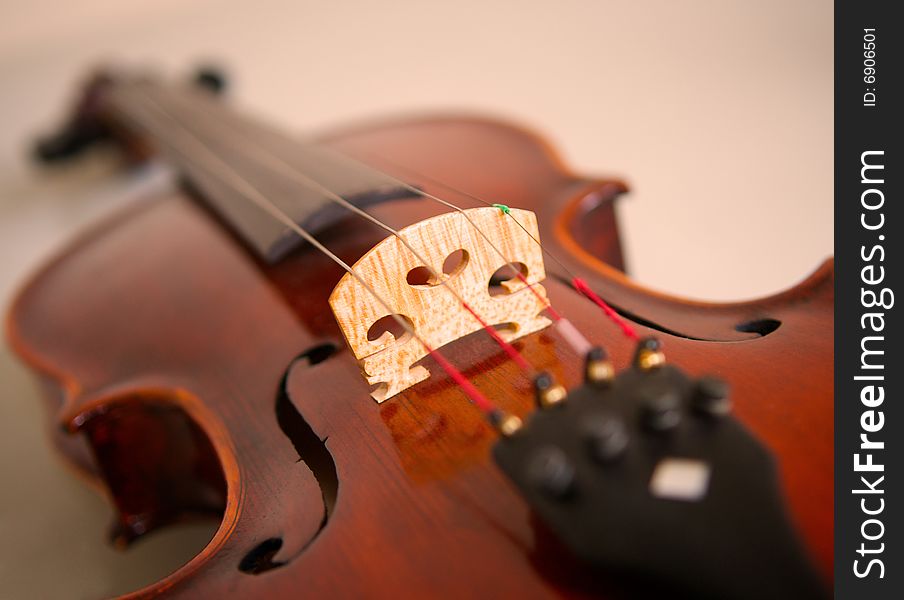 A handmade violin with selective focus on the bridge and f-holes. A handmade violin with selective focus on the bridge and f-holes