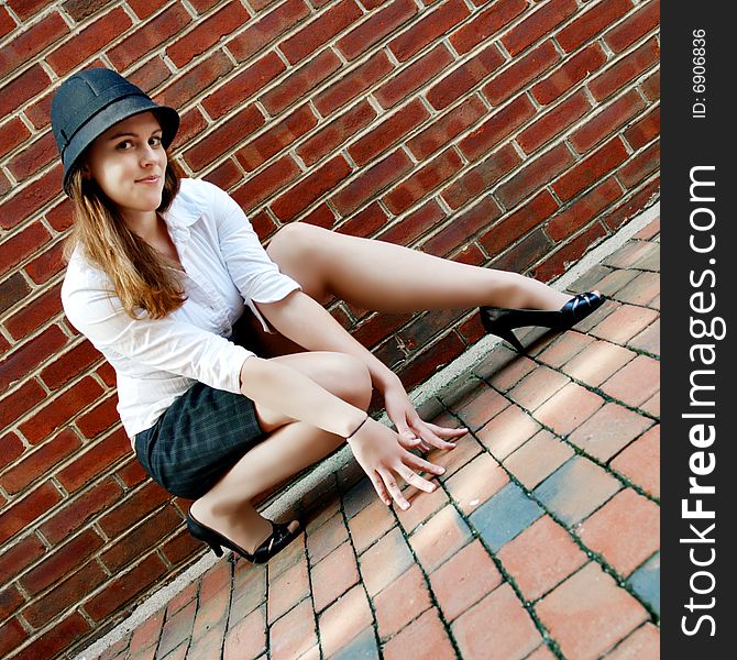 Fashionable young woman posing in front of a brick wall. Fashionable young woman posing in front of a brick wall.