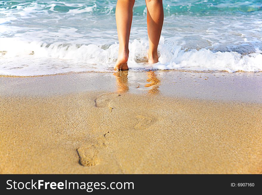 Woman's legs, going to sea with footsteps