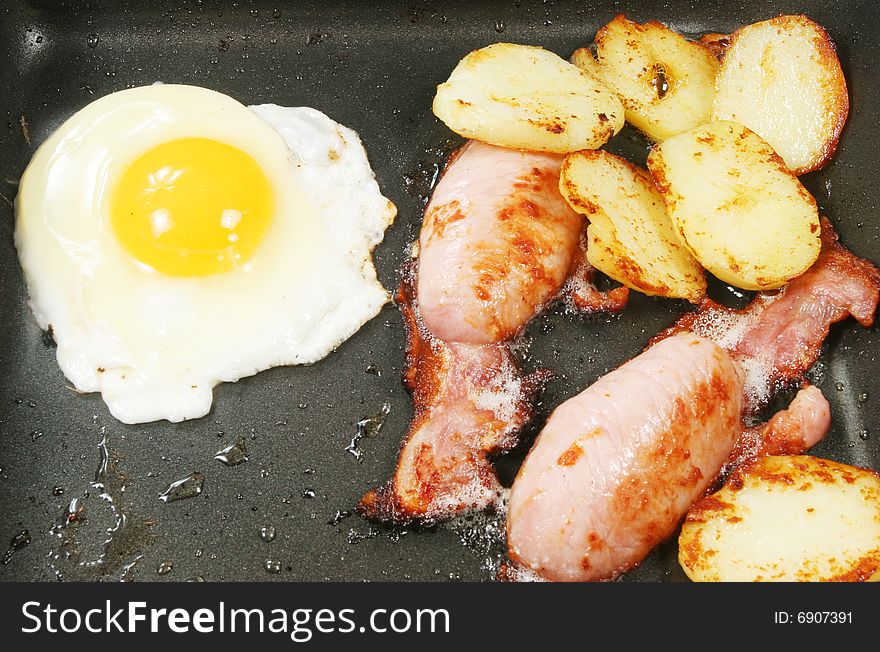 Egg bacon and potatoes frying in a pan. Egg bacon and potatoes frying in a pan