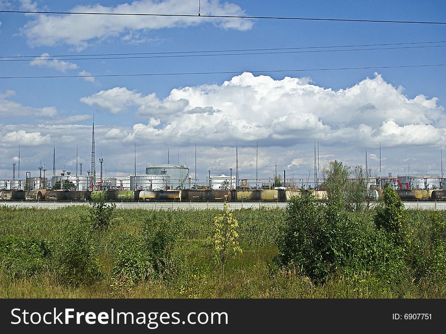 Rolling-stock of the cisterns and behind him is the oil storage