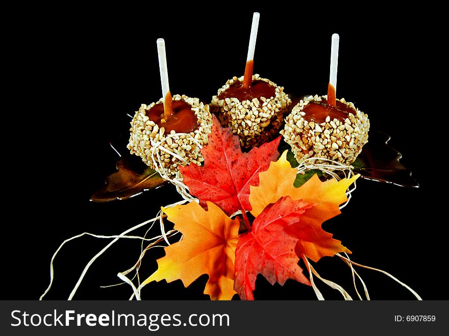 Caramel apples and fall leaves on a leaf plate. Caramel apples and fall leaves on a leaf plate.