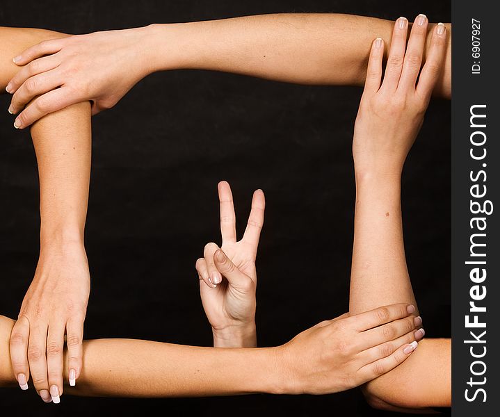 Frame from hands with victory gesture over dark background. Frame from hands with victory gesture over dark background