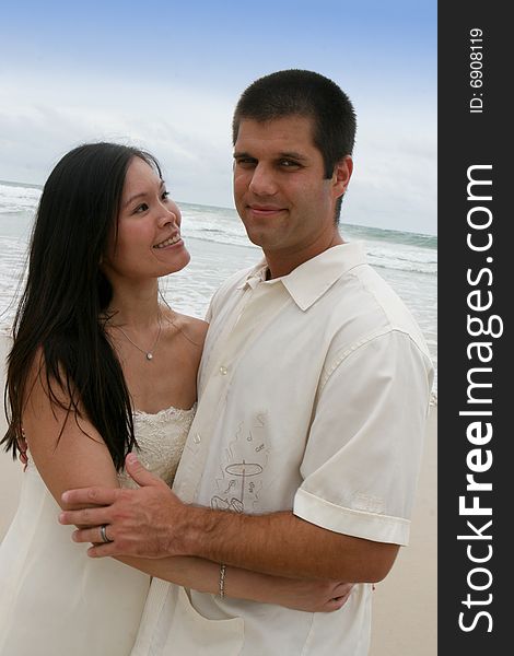 Portrait of an attractive bride and groom on the beach. Portrait of an attractive bride and groom on the beach.