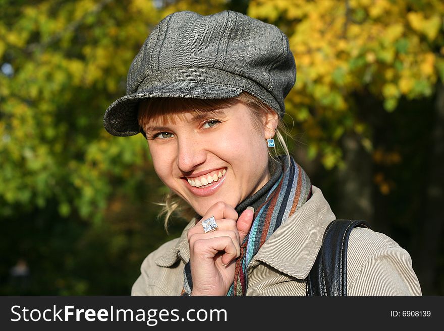 Beautiful blond young woman in cap in autumn park