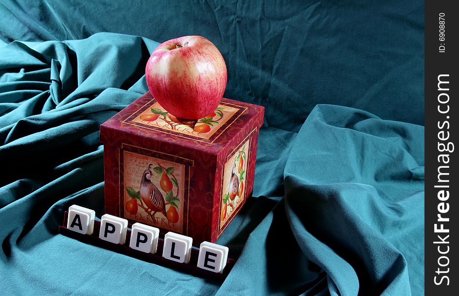 Apple on a box with the word apple in the foreground. Apple on a box with the word apple in the foreground