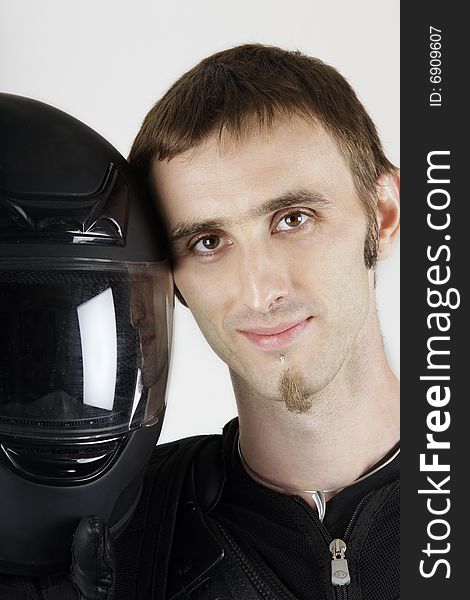 Portrait of smiling biker with had next to a sports helmet. Portrait of smiling biker with had next to a sports helmet