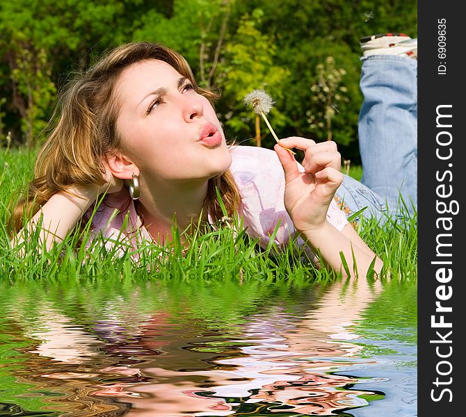 Young girl blowing on the dandelion