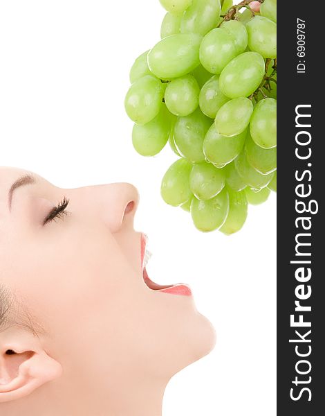 Pretty woman with green grape isolated on the white background