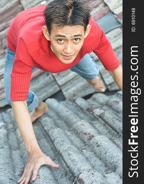 Man climbing roof tile or pantile. Man climbing roof tile or pantile