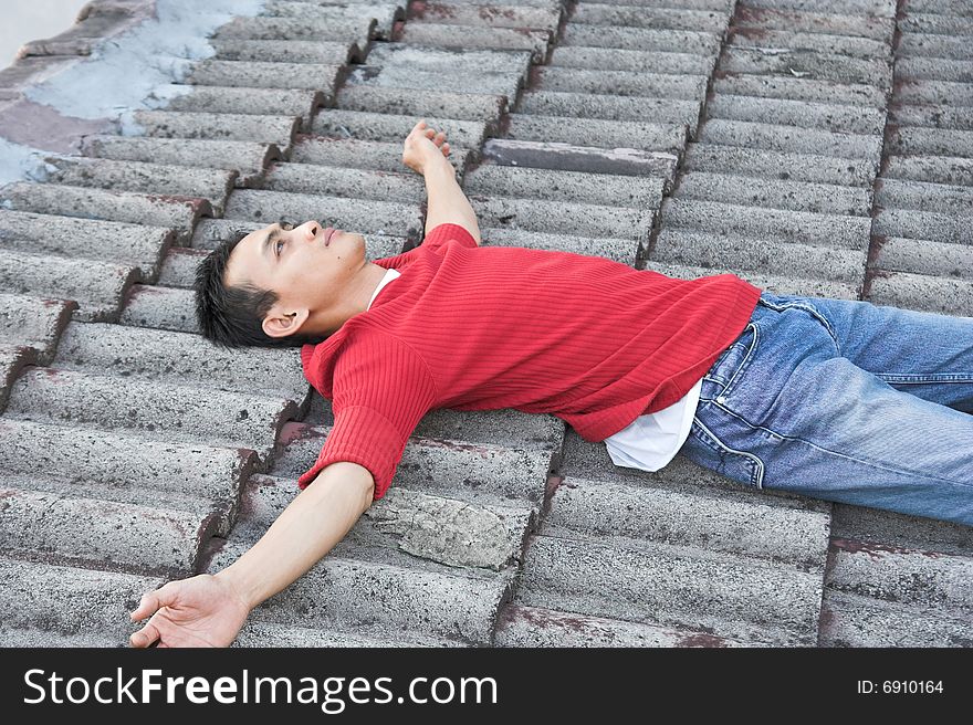 Man lie down on the roof tile. Man lie down on the roof tile