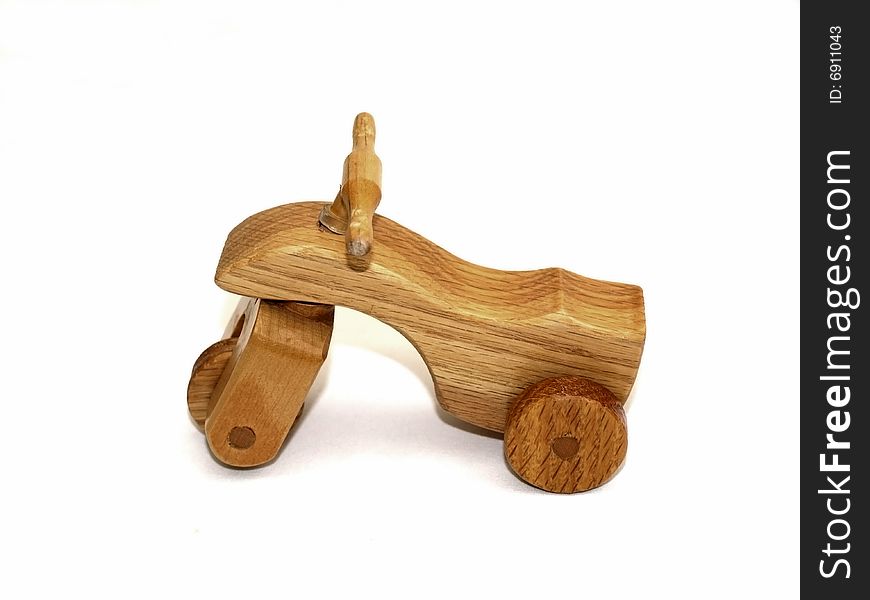 Wooden toy three-wheeler, side-view, on white background. Wooden toy three-wheeler, side-view, on white background