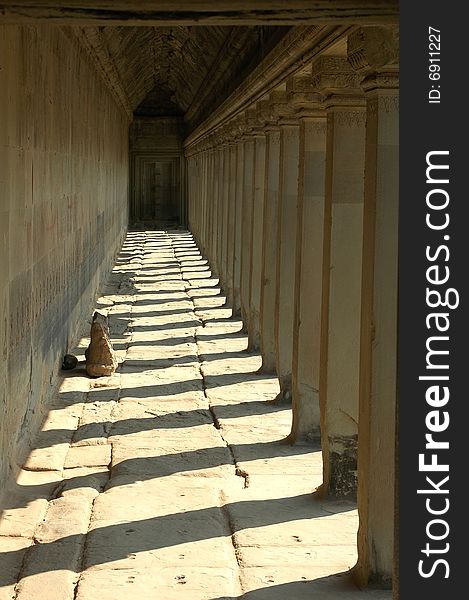 A porch bordered by colonnades with shadows in Angkor,Cambodia