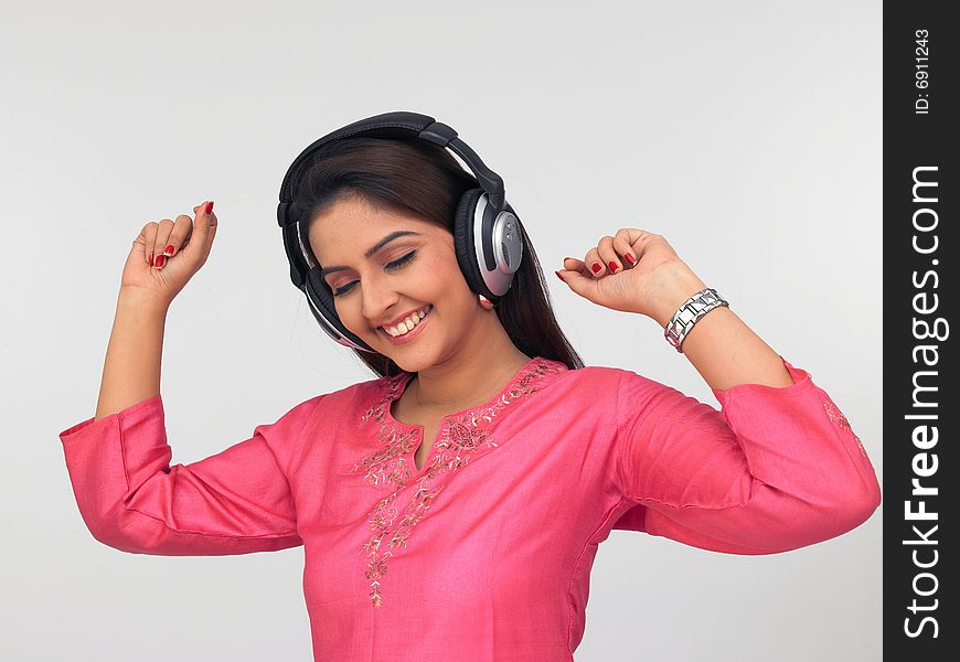 A pretty asian woman wearing a headphone and listening to music. A pretty asian woman wearing a headphone and listening to music