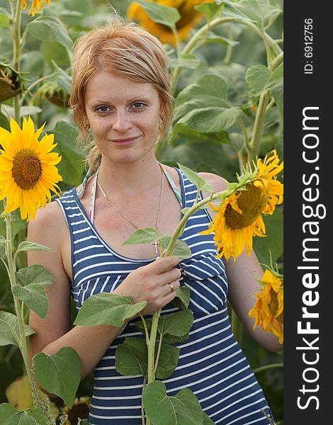 She is beaty girl and sunflower in a field. She is beaty girl and sunflower in a field