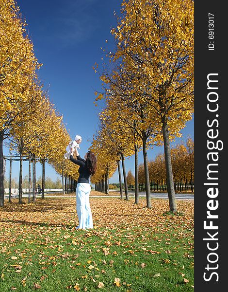 Mother and daugther playing in the park on a sunny autumn day