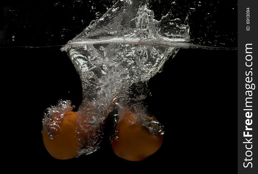 Splashing persimmons on black.Series of splashing fruits. Splashing persimmons on black.Series of splashing fruits