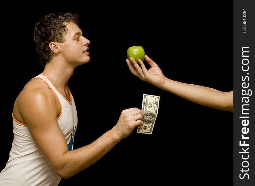 Young man pay for apple. Young man pay for apple