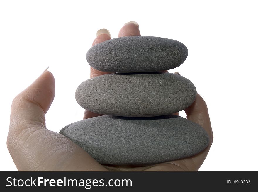 Three balanced rocks in hand on white