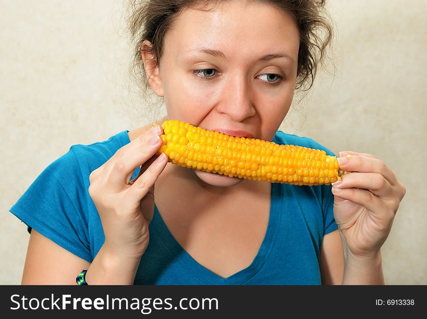 Nice young girl eating yellow corncob. Nice young girl eating yellow corncob