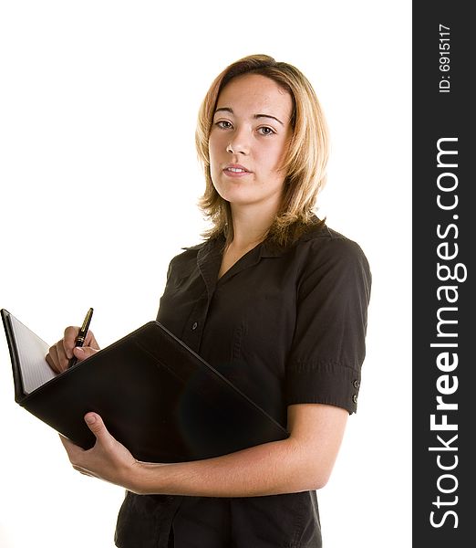 A blonde in black shirt writing in a notebook. A blonde in black shirt writing in a notebook