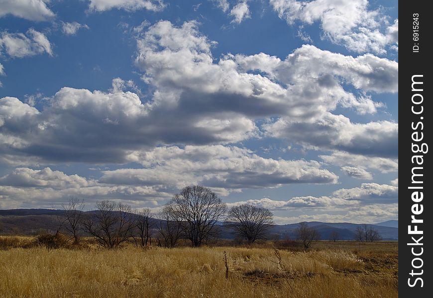 An autumn landscape with a meadow and clouds. An autumn landscape with a meadow and clouds