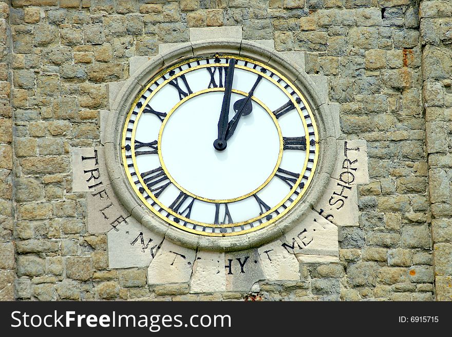 An old church clock face set in a stone wall