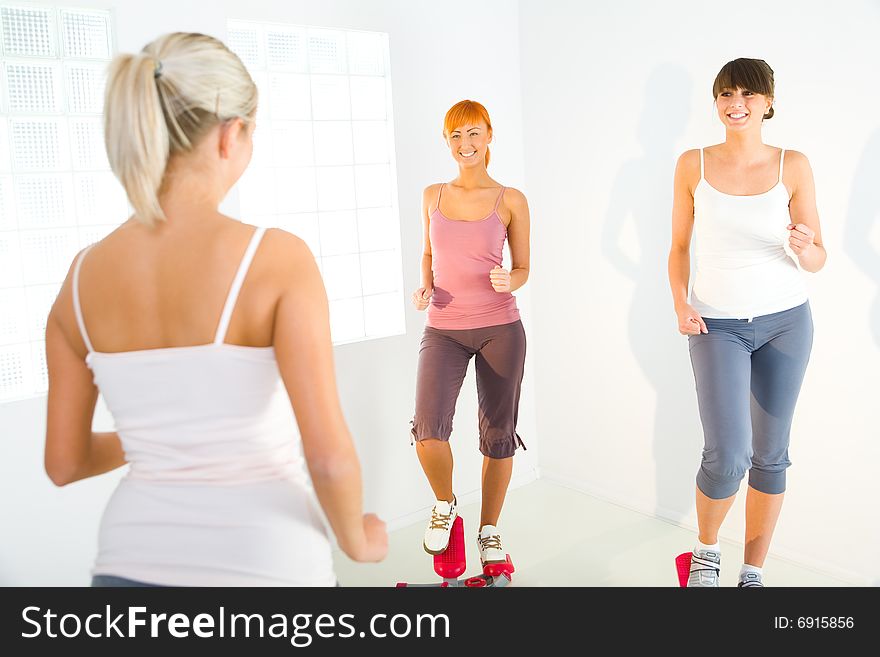 Women exercising on stepping machine