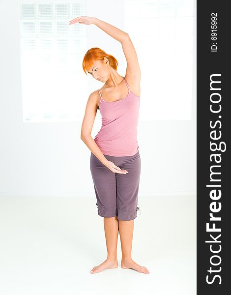 Young red-haired woman doing fitness exercise.  Front view. Young red-haired woman doing fitness exercise.  Front view.