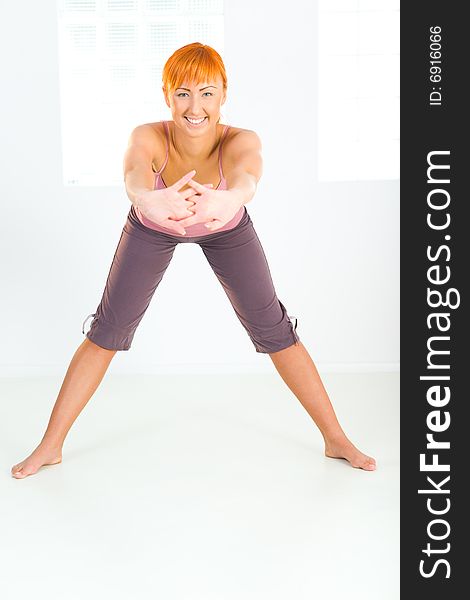 Young woman doing fitness exercises. She's looking at camera. Front view. Young woman doing fitness exercises. She's looking at camera. Front view.