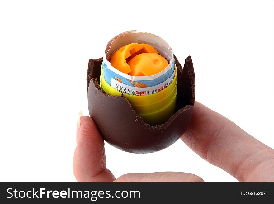 An Isolated to White photo of a mini Easter Egg with toy held between fingers. An Isolated to White photo of a mini Easter Egg with toy held between fingers