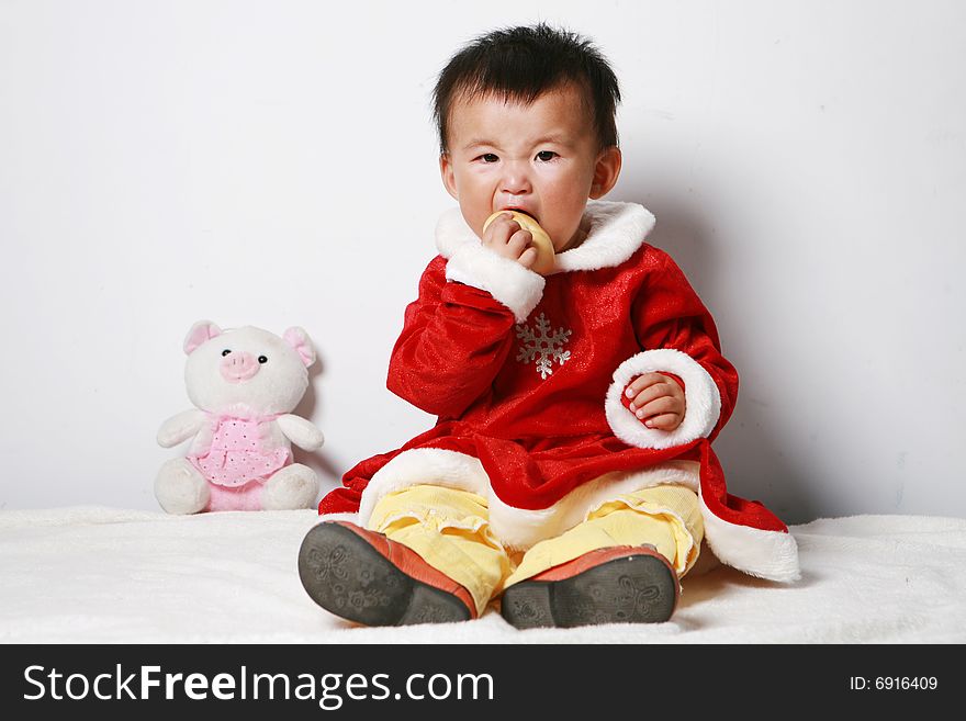 Santa baby eating bread ,some toy arround her