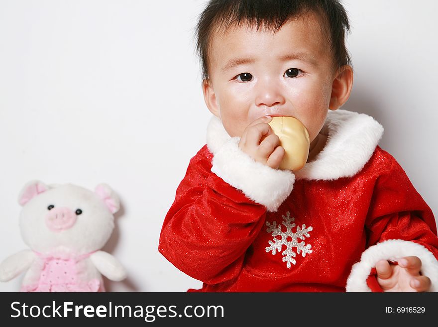 Santa baby in red dress, eating.